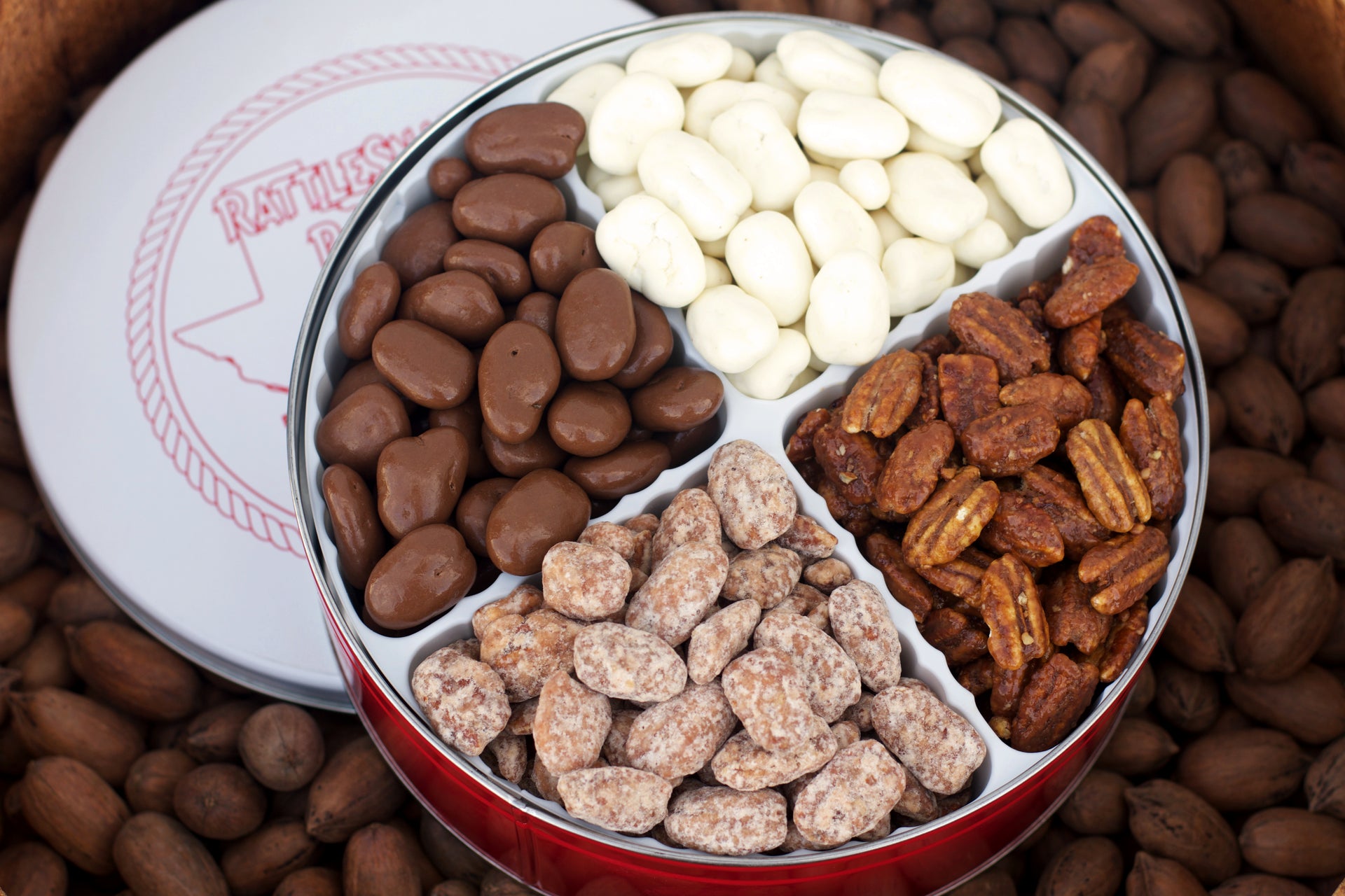 Our 4 Way Pecan Gift Tin includes four of our most popular candied pecan flavors! Milk Chocolate Pecans, White Chocolate Pecans, Honey Toasted Pecans and Praline Pecans! This tin includes 3.5 pounds of candied pecans. 